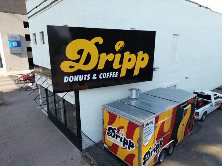 Dripp Hot Chicken Aluminum Sign mounted to a frame on the building